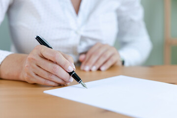 Businesswoman signing an official document.