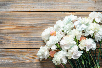 Bouquet of white carnations on a wooden background, flat lay.