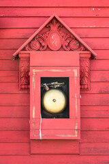 Close-up of a vintage red fire station bell on outside wall of fire department