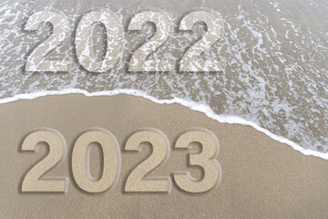 2023 new year concept, sandy beach and foam wave on beige color background. Relaxation mode on the beach concept, copy space.