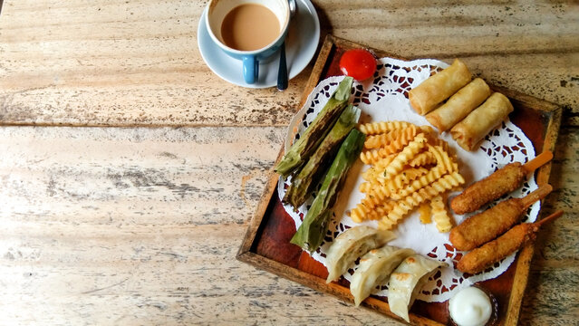 Snack Platter Consisting Of French Fries, Otak Otak, Dragon Feet, Dimsum, Spring Rolls With Tomato Sauce,mozzarella And Cappucino