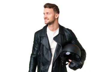 Young caucasian man with a motorcycle helmet over isolated chroma key background looking to the side and smiling