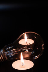 Electric lamp and candle on a dark background. Incandescent lamp and candle. No or power outage....
