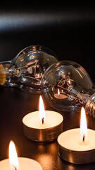 Electric lamp and candle on a dark background. Incandescent lamp and candle. No or power outage....