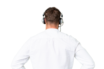 Telemarketer caucasian man working with a headset over isolated chroma key background in back position