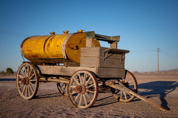Fototapeta na wymiar Old horse-drawn wooden cart with a yellow tank