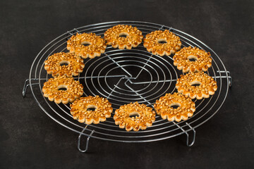 Small Nut cookies in the shape of a ring, on a serving stand. Dark gray background
