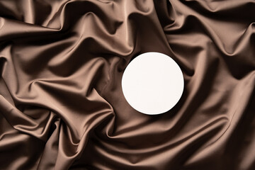 Minimal scene for product presentation made with white circle mockup podium on a silk cloth. Top view.