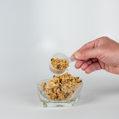 Scooper measure out granola for a snack