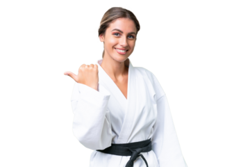 Young Uruguayan woman doing karate over isolated background pointing to the side to present a product