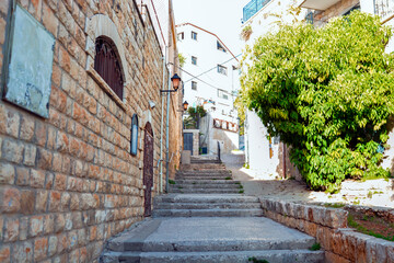 Charming streets of israel Crete. Street in the old town of Beautiful street in Safed, Israel, Summer landscape. Travel and vacation View of an alley in the Artists Quarter of the old city of Safed	
