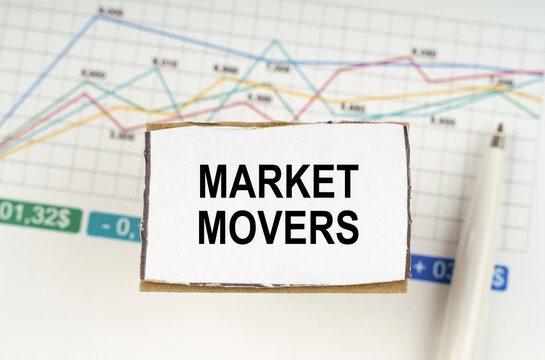 Against the background of business graphics and pens, a sign with the inscription - Market Movers