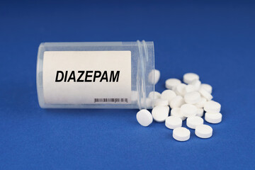 On a blue surface are pills and a dusty jar with the inscription - Diazepam