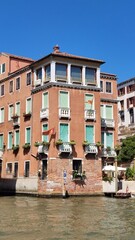 View of the Venetian Canal on a sunny day, buildings and boats. Venice, Italy