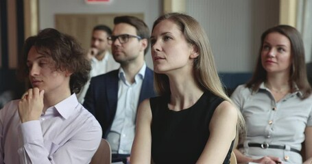Young seminar participants applaud to speaker, finish group workshop gathered in conference hall. Businesspeople clap hands greeting or congratulate business speaker or trainer, express acknowledgment