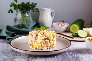 Olivier salad on a plate ingredients for its preparation on the table. Christmas snacks