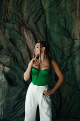Obraz premium beautiful brunette in a green top shows off her breasts after plastic surgery