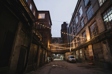 Dark street in an industrial area illuminated by small lanterns
