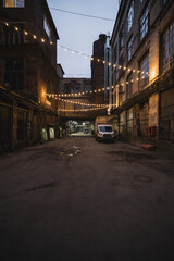 Dark street in an industrial area illuminated by small lanterns