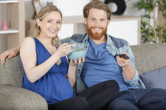 happy young couple preparing to watch a movie at home