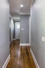 a long hallway with gray walls and hardwood floors