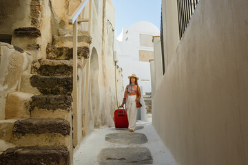 Young woman with  walks through the old streets in Greece