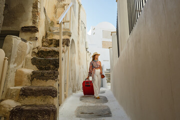 Young woman  walks through the old streets in Greece