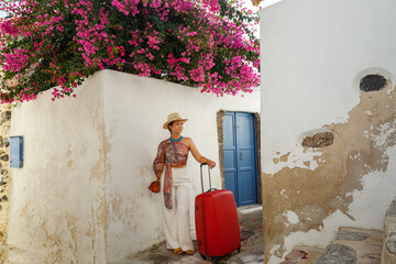 Young woman with a red suitcase in island  Santorini