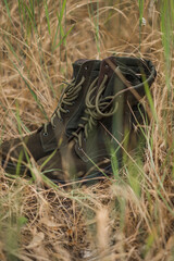 Army boots in dry grass. Military footwear. Sneakers for mountain terrain