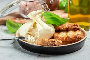 Italian burrata cheese, white balls of burrata or burratina cheese Basil and Olive Oil and...