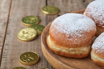 Happy Hanukkah. Hanukkah sweet doughnuts, gift boxes, white candles and chocolate coins on old  wooden background. Image and concept of jewish holiday Hanukkah. Top view.