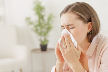 a girl in light clothes suffers from a headache holding on to her temples, migraine,