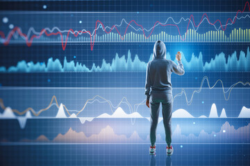 Back view of hacker using digital business graph hologram on blurry blue background. Trade, data...