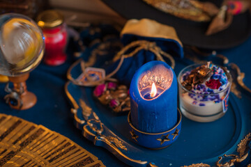 Fortune-telling cards and burning candles on a table on mystic background 