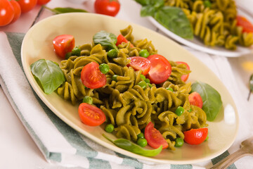 Fusilli pasta with cherry tomatoes and peas.