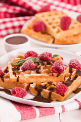 Waffles with raspberries and chocolate cream.