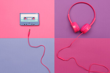A-side of blue  audio cassette on a pink background and pink headphones on a violet  background.
