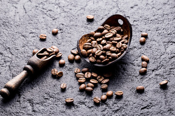 Roasted coffee beans with wooden spoon, closeup image, space for text