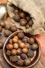 New harvest of ripe fresh Australian macadamia nuts in shell with leaves