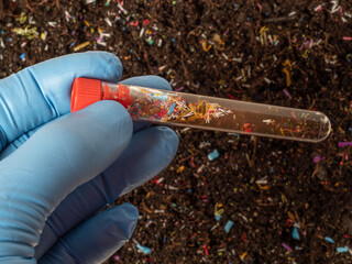 Microplastics in soil a test tube with soil sample - soil contaminated with mineral microplastics - 553049229