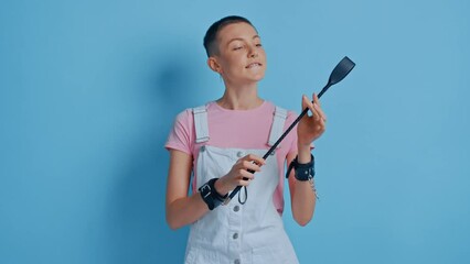 Confident bdsm woman posing with black whip and enjoying dominance at relationships