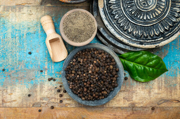Indian spices collection, dried black peppercorns and another spices in clay bowls