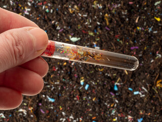 Microplastics in soil a test tube with soil sample - soil contaminated with mineral microplastics