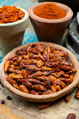 Colorful ground spicy chili peppers , pimento and curcuma is clay pots close up