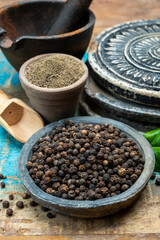Indian spices collection, dried black peppercorns and another spices in clay bowls