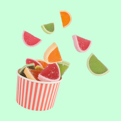 Jelly sweets colorful candies are flying from round striped box. Sweet confectionery candy gumdrops concept idea photo