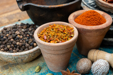 Colorful ground spicy chili peppers , pimento and curcuma is clay pots close up