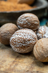 Nutmeg powder. Macro view whole nuts and grated muscat nuts on vintage background.