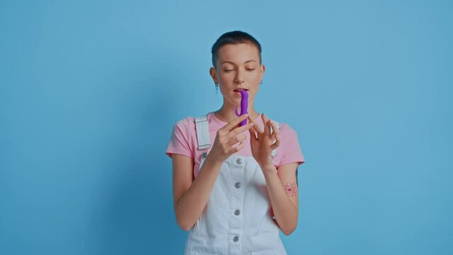 Woman wearing domestic clothes posing with sex self clit and vagina stimulator