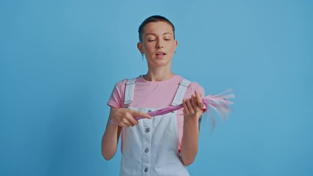 Serious bdsm woman posing with pink whip enjoys unequal power relationships including bondage